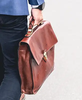 Person walking with a leather briefcase